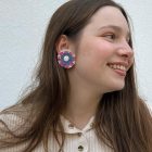 Recycled plastic stud earrings, floral shaped, with a natural shell.