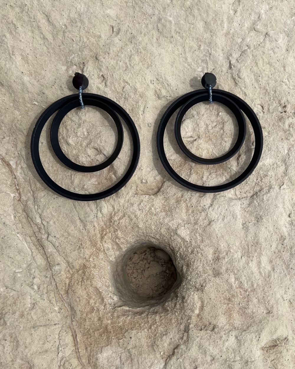 Minimalist earrings crafted from spotlight parts, featuring large metal circles in sleek black or white for a bold, modern look.